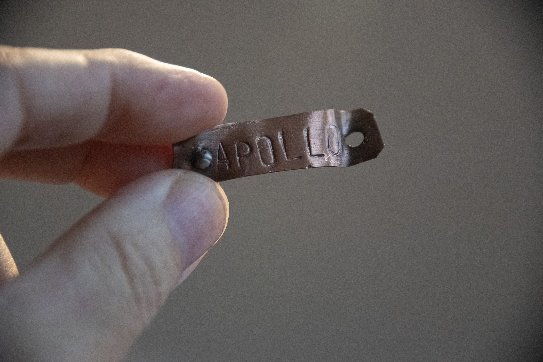 A piece of copper labelled 'Apollo', bent and discolored